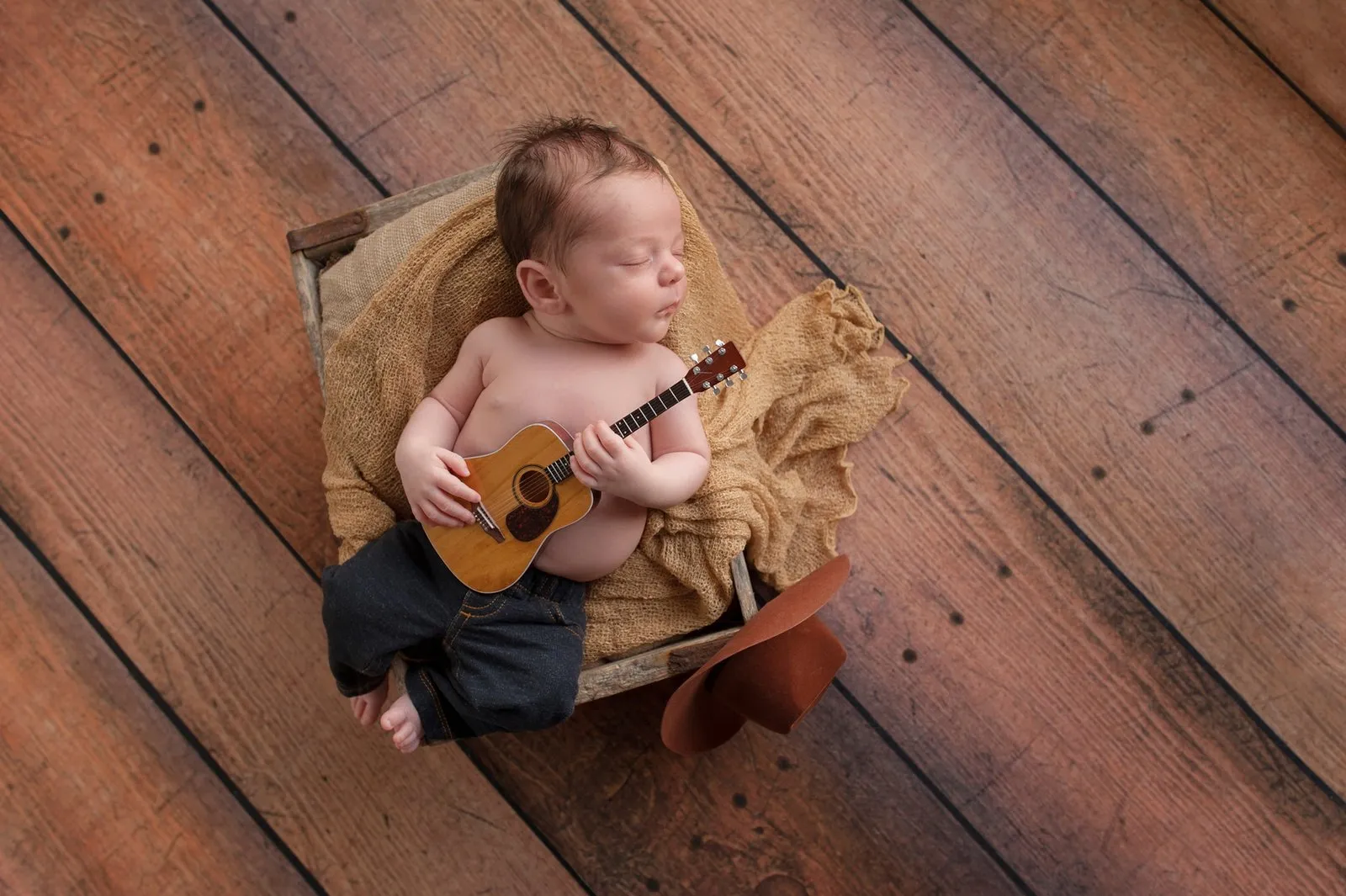Bebé dormido con una pequeña guitarra entre las manos